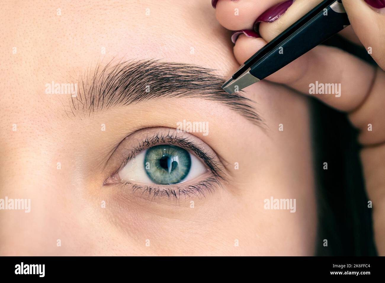 Make-up. Eyebrow Makeup. Eyes. procedure for plucking eyebrows in a beauty salon close-up. Stock Photo