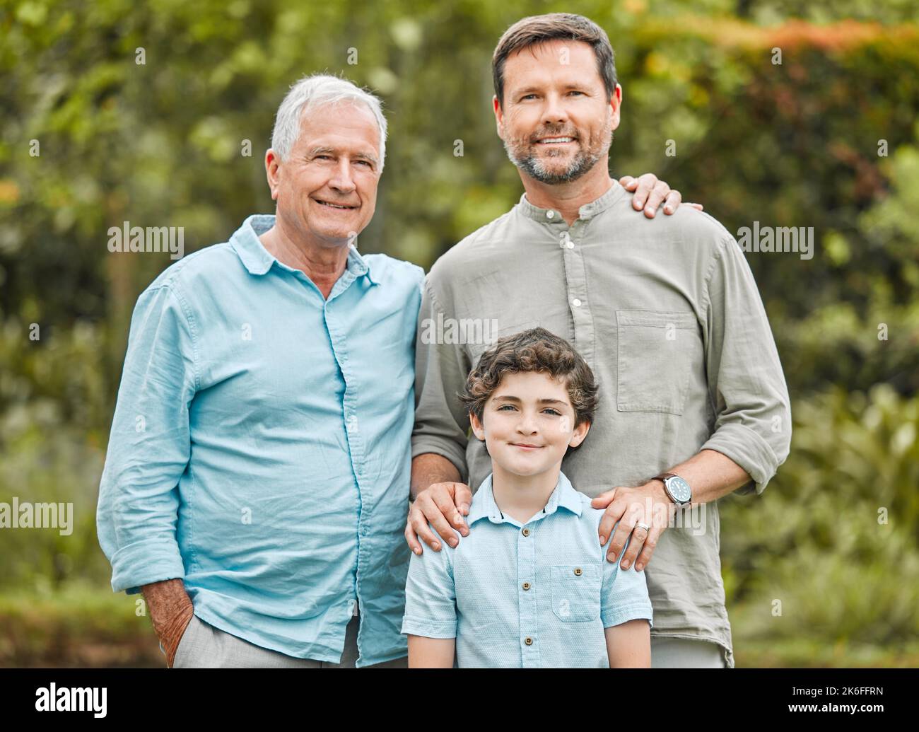 We have little eyes watching and imitating what we do. a boy standing outside with his father and grandfather. Stock Photo