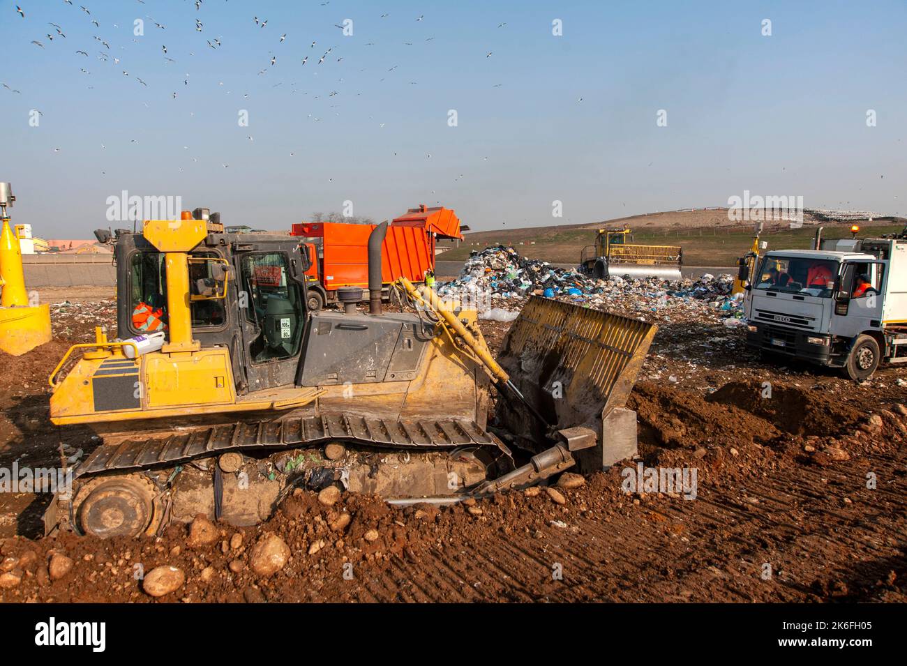 Municipal waste landfill. Workers with trucks and bulldozers at work in
