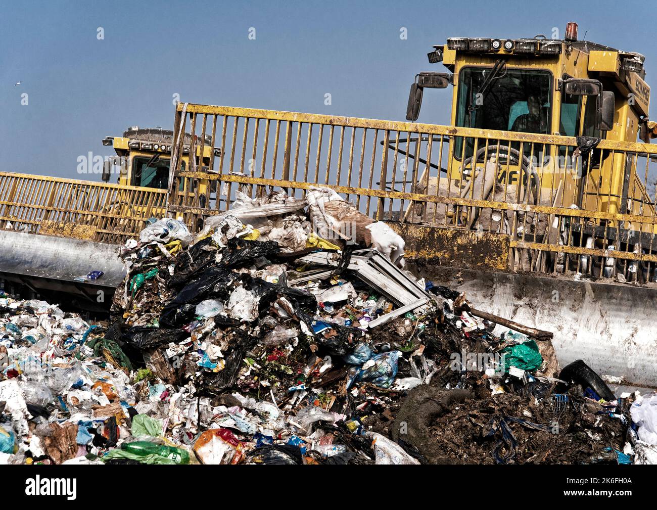 Municipal waste landfill. Workers with trucks and bulldozers at work in