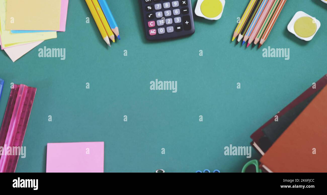 Overhead view of multicolored pencils with calculator, ruler, sticky ...