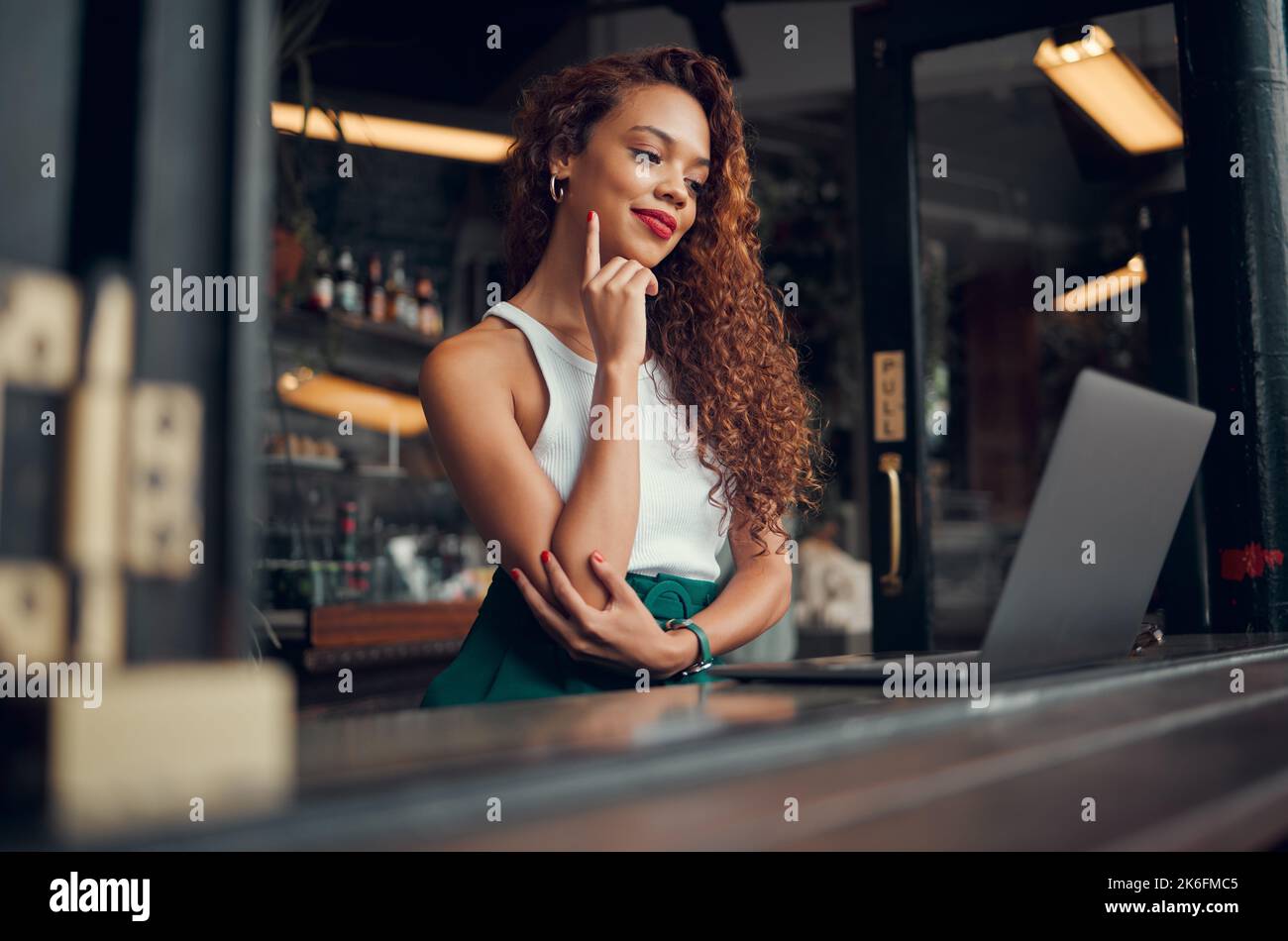 Woman, laptop and thinking in coffee shop, restaurant or Brazilian cafe for remote work, fashion blog writing or ebook ideas. Happy smile, student or Stock Photo