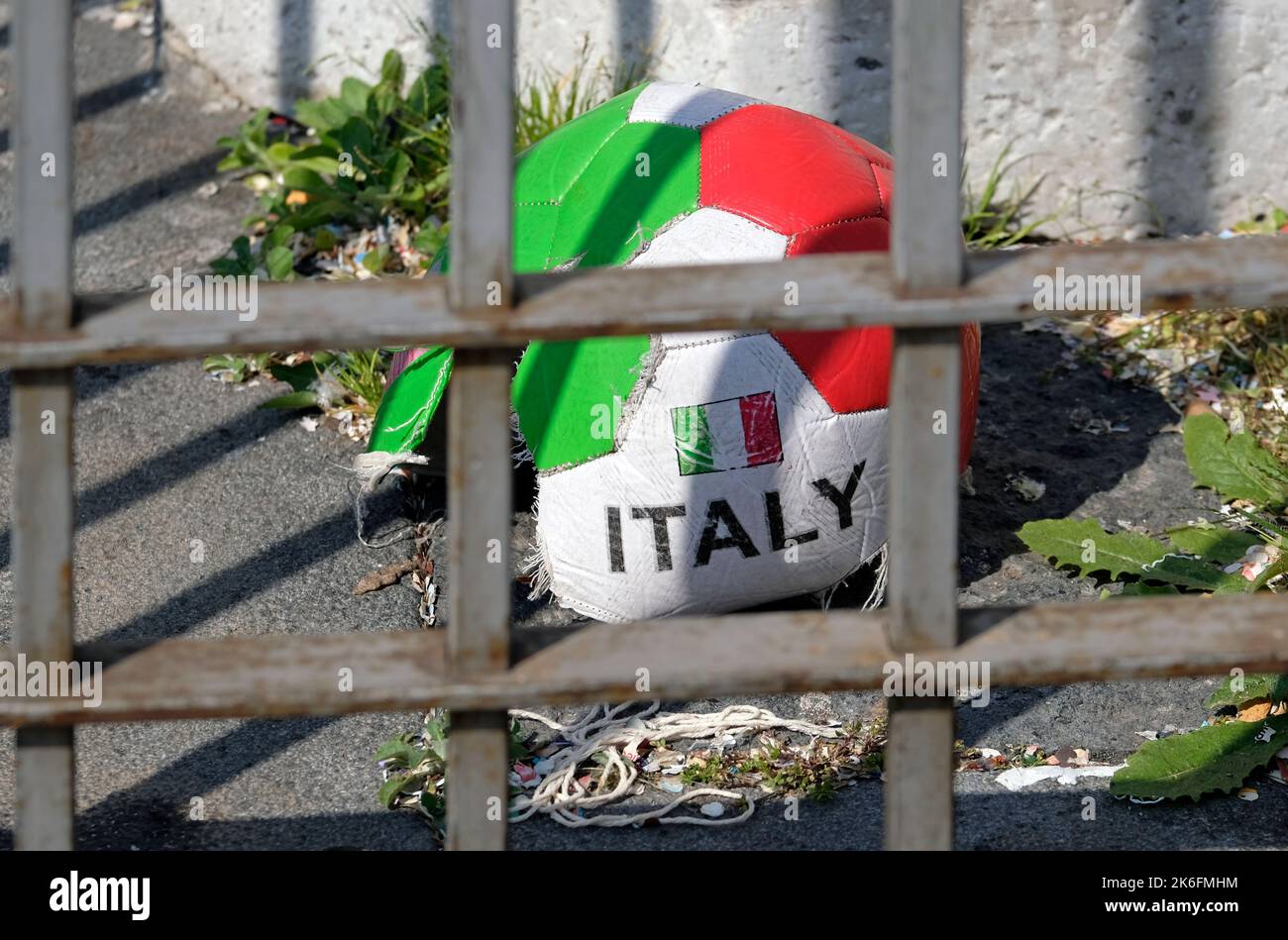 Damaged Football Damaged football with the colors of Italy behind a metal gate Stock ...