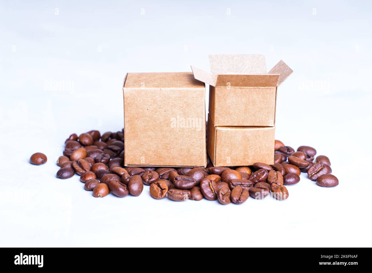Miniature cardboard boxes and roasted coffee beans isolated on a