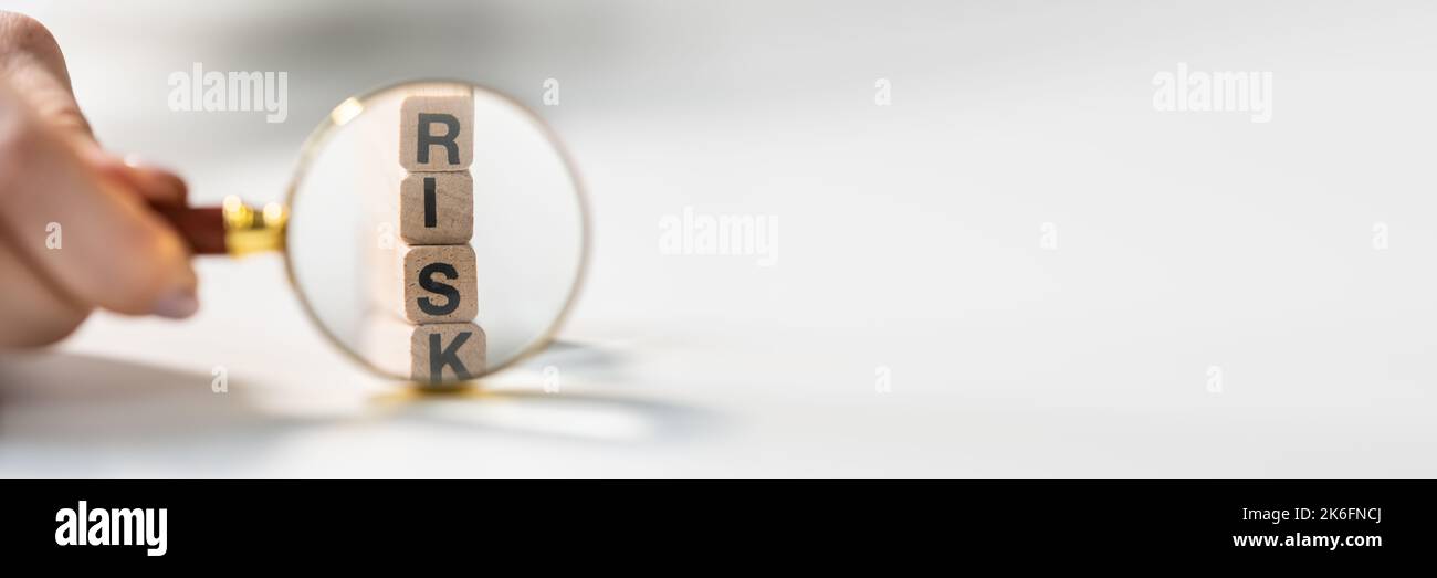 Risk Detection Using Magnifying Glass. Wooded Block Word Stock Photo