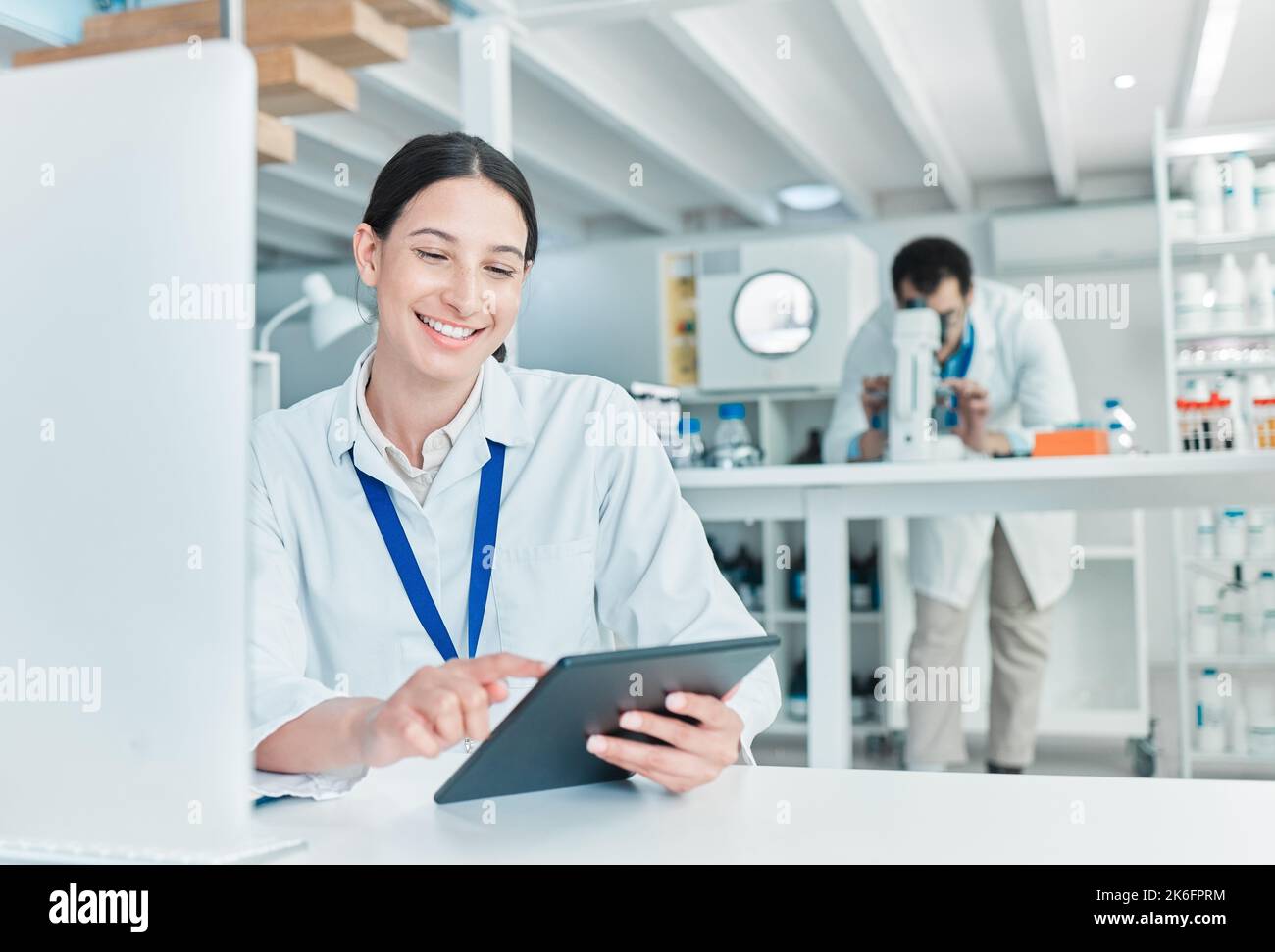 Doing it all digitally. a young scientist working on a digital tablet and computer in a lab. Stock Photo
