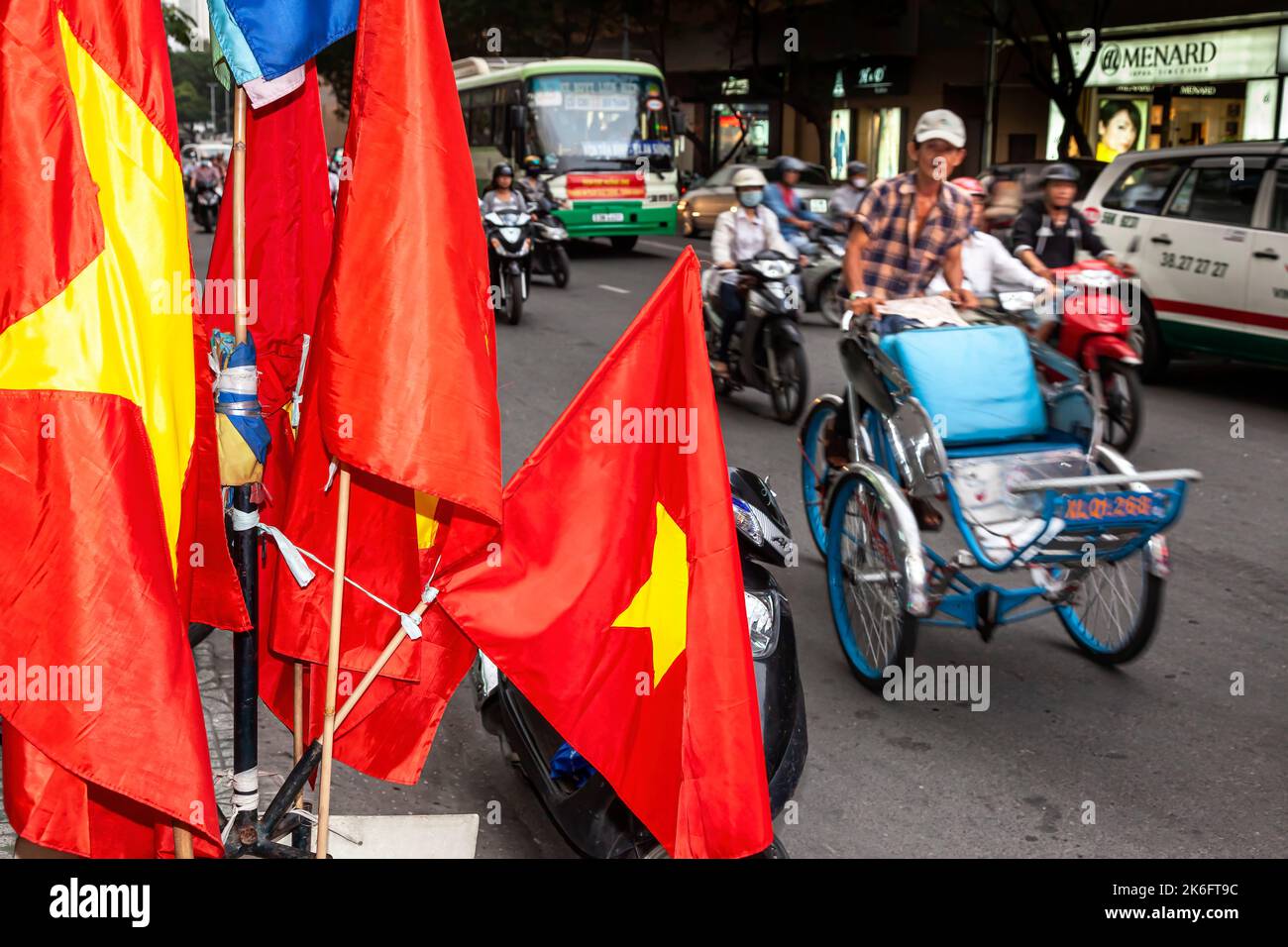 Traffic and flags on the street in central Ho Chi Minh City, Vietnam Stock Photo