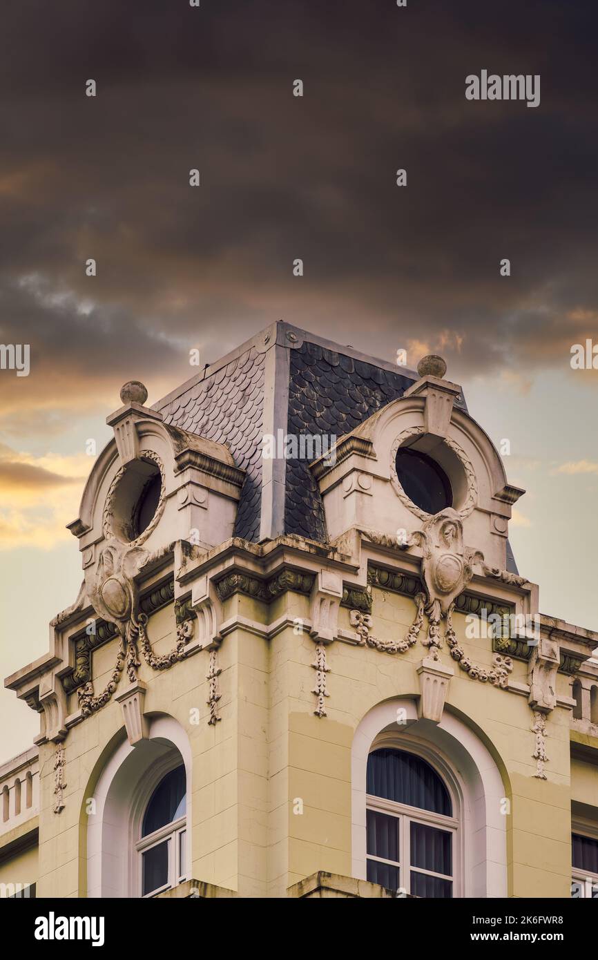 Neoclassical attic roof house round windows with decoration against