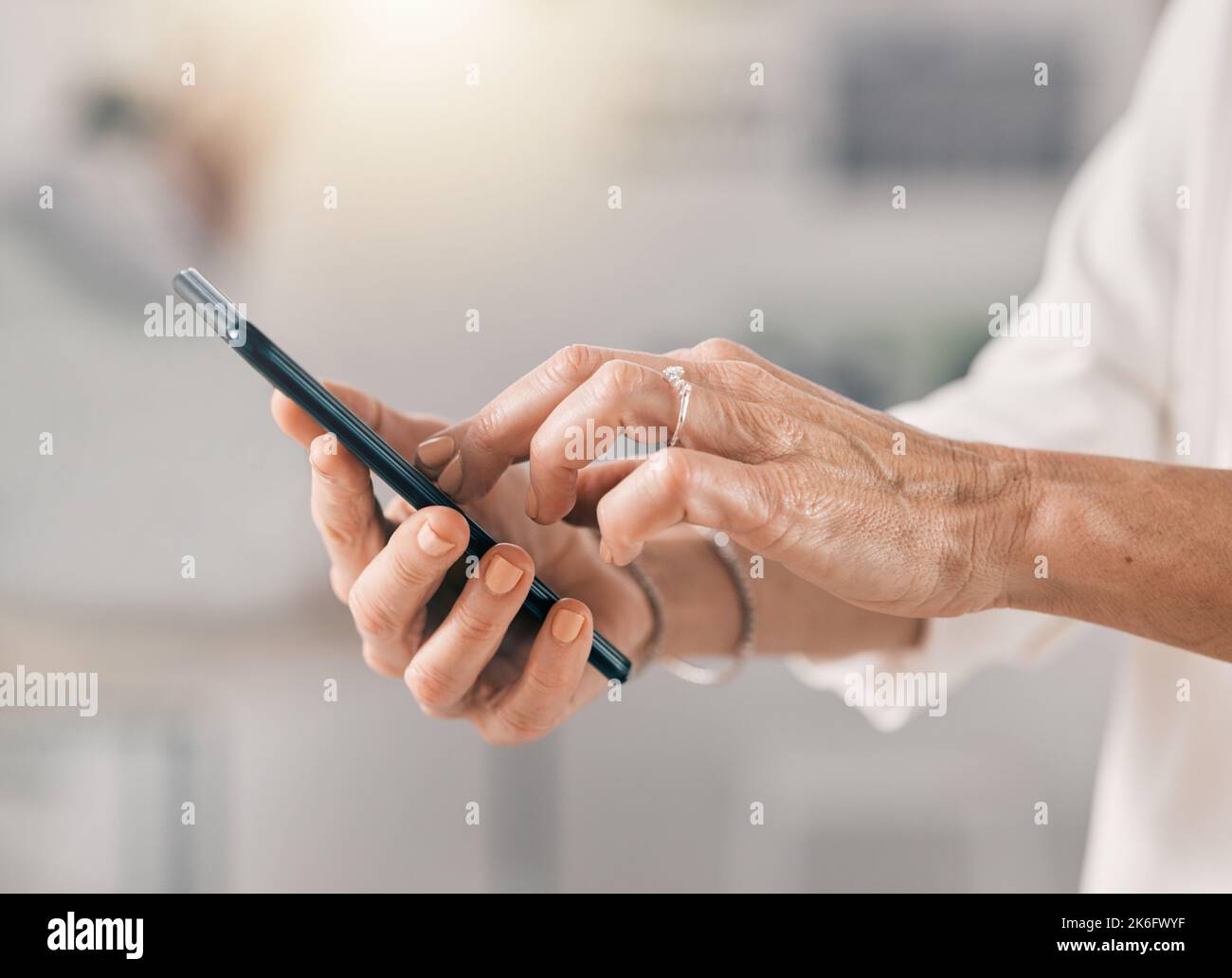 Early morning doings...an unrecognizable businesswoman using her cellphone at work. Stock Photo