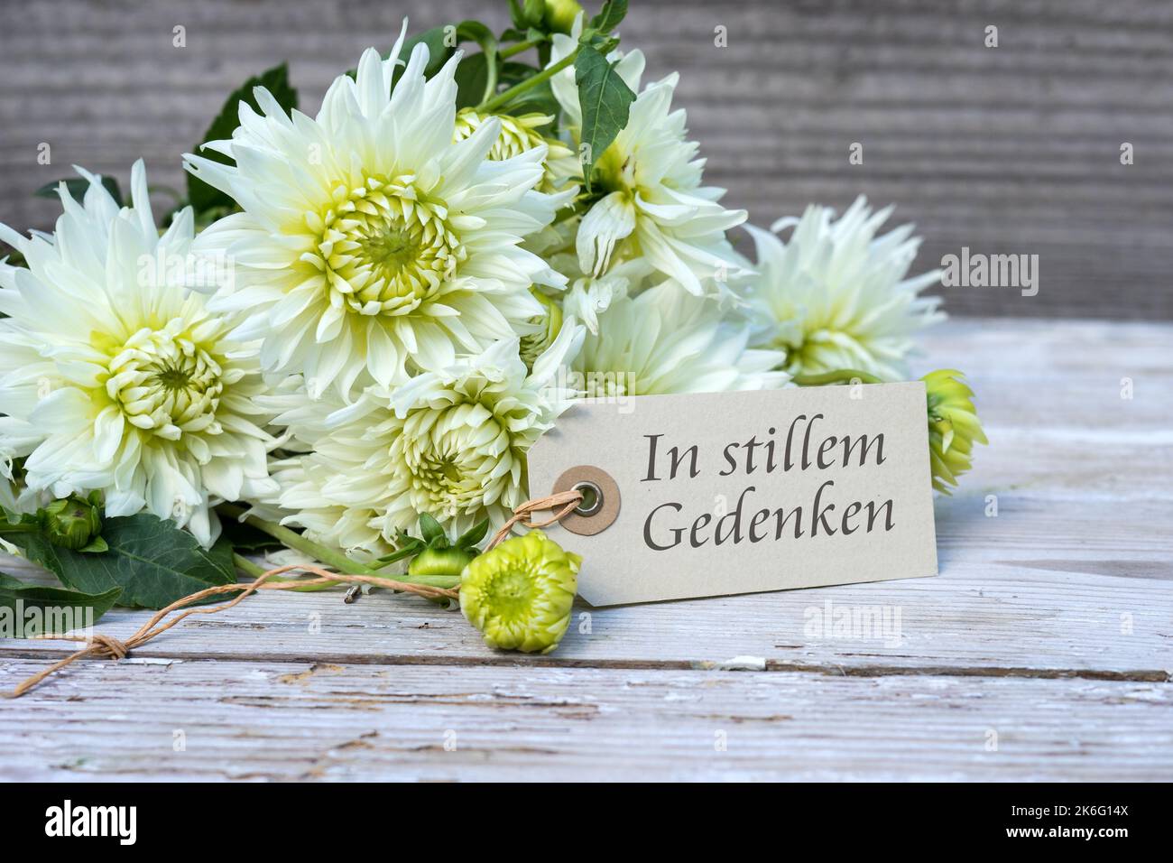 Mourning card with white dahlias and German text: In silent memory Stock Photo