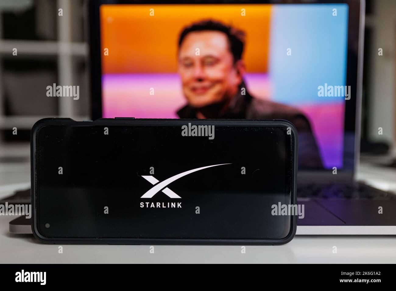 Kaunas, Lithuania - 14 October 2022: Starlink logo on screen and Elon Musk in background Stock Photo