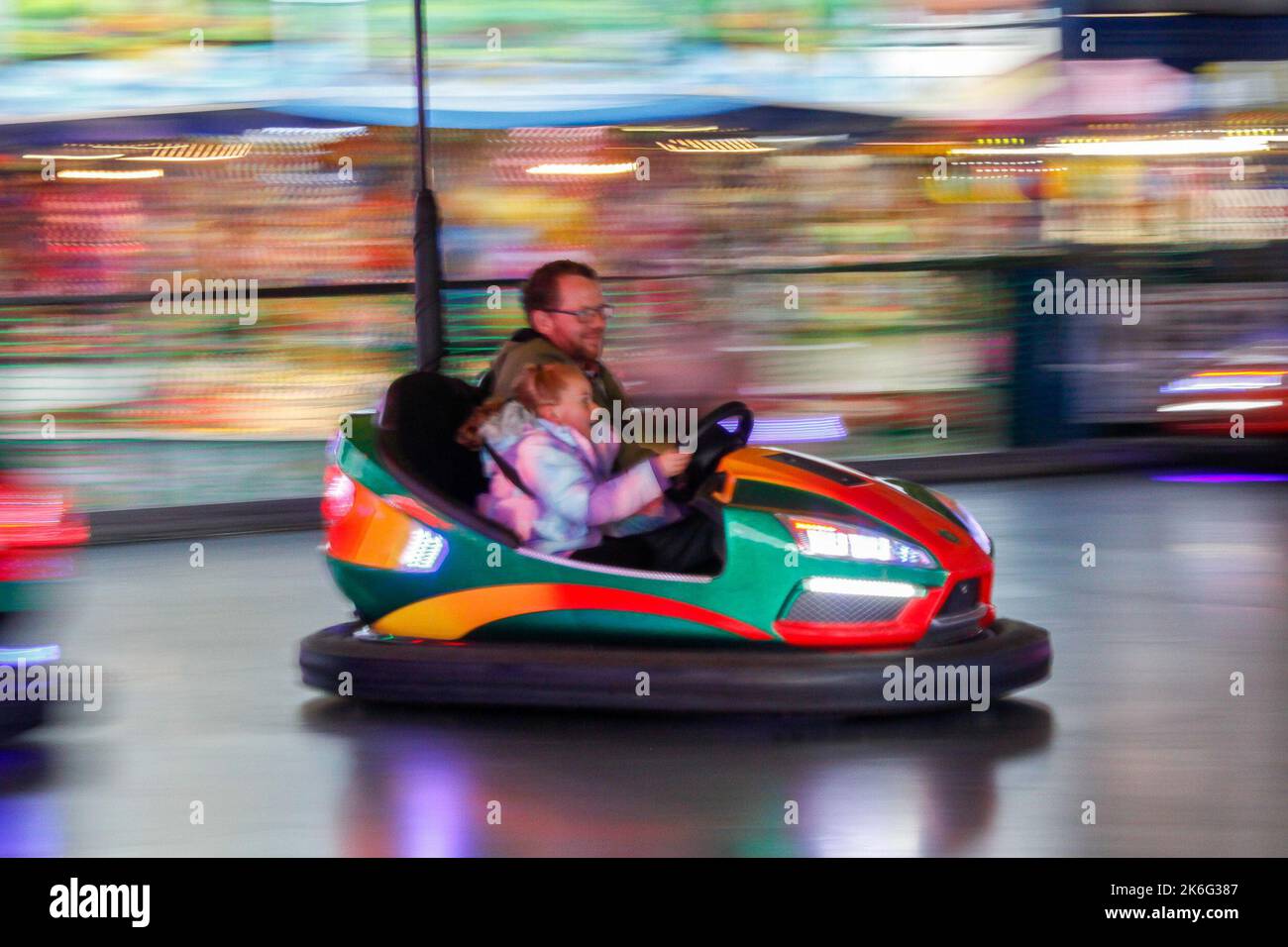 Father and Daughter riding the dodgems fair ride at Tewkesbury MOP fair