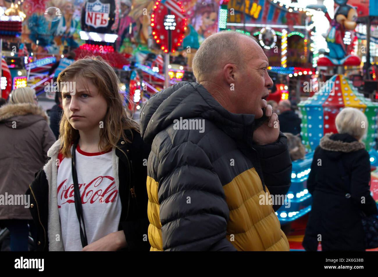 Young Girl and man looking lost in the crowd at the Tewkesbury MOP fair, 7th October 2022 Stock Photo