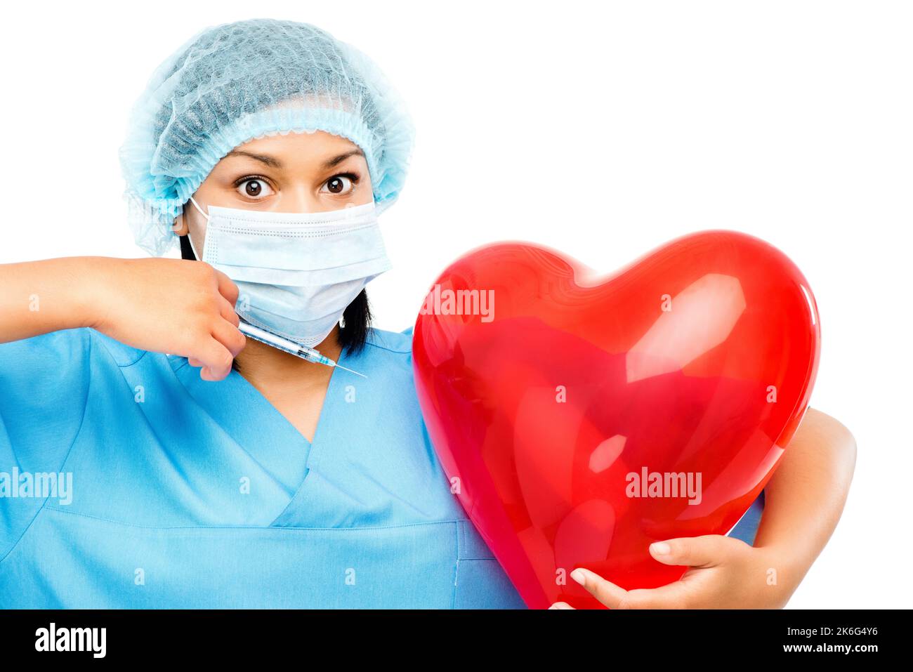 Helping your heart grow twice its size. a female nurse holding a heart shaped balloon ready to inject it against a studio background. Stock Photo