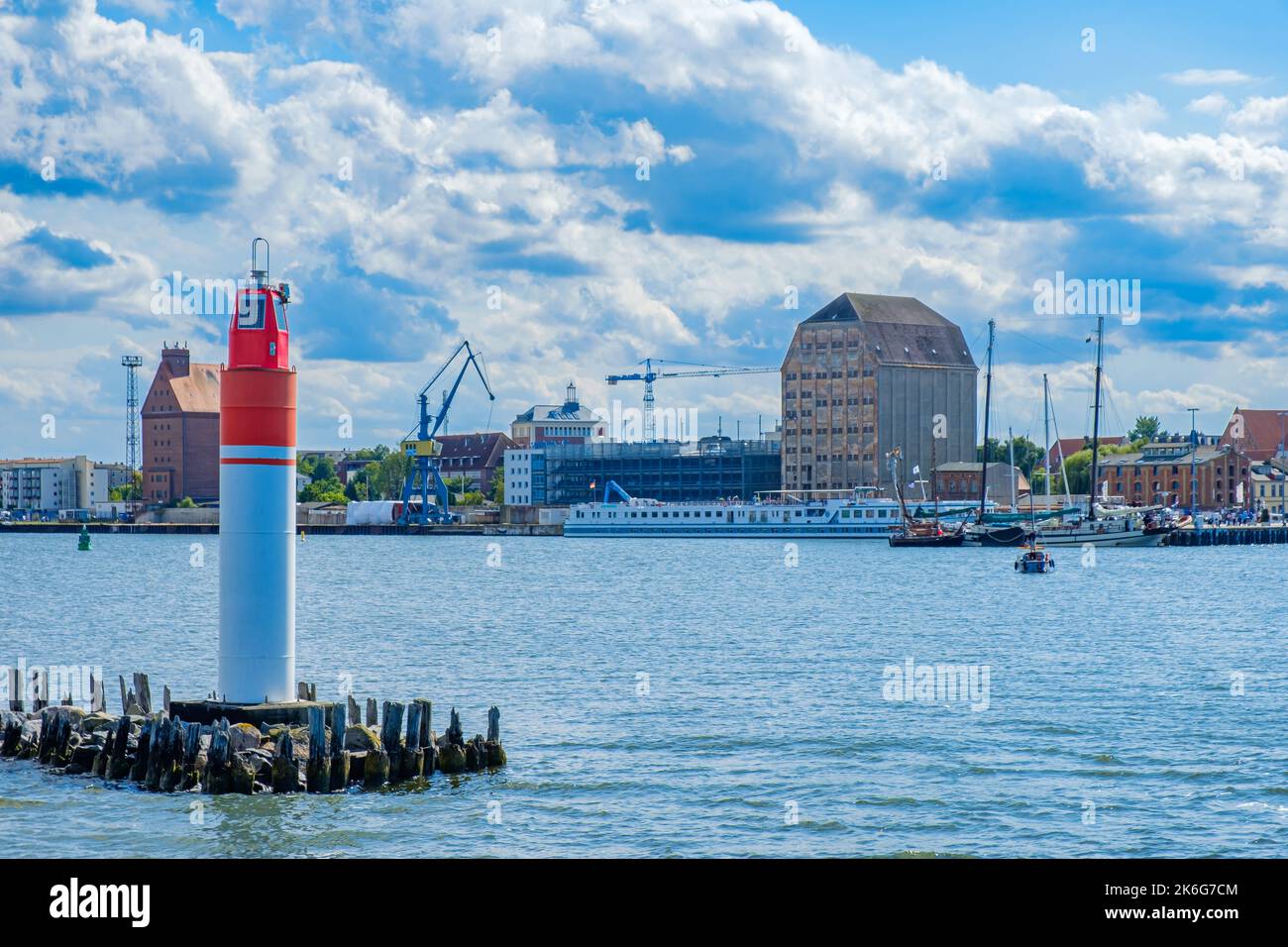 Seaside view from the Strela Sound onto the central breakwater light, the town backdrop and harbour front of the Hanseatic Town of Stralsund, Germany. Stock Photo