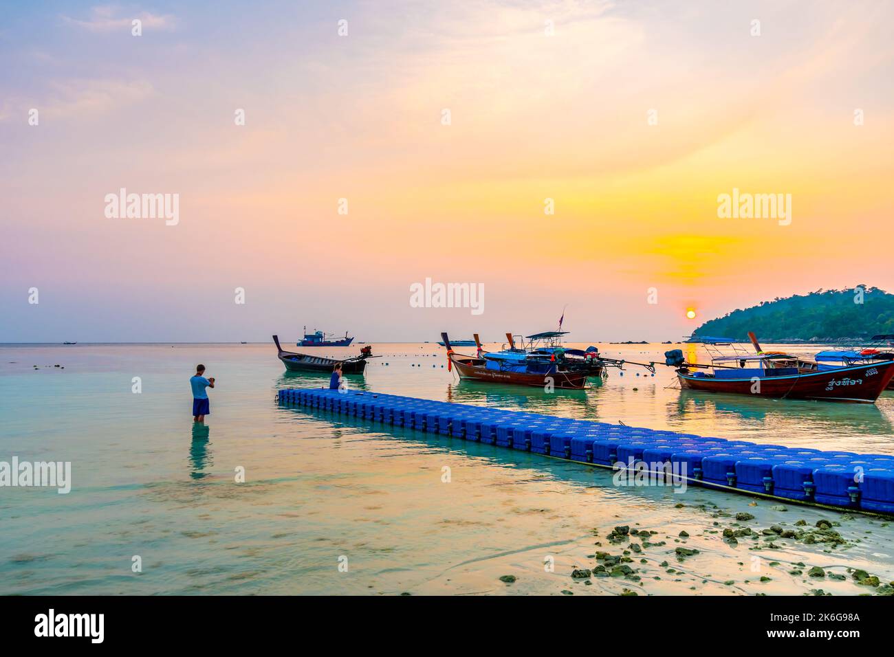 Koh Lipe, Thailand - 13.11.2019: Tourists are taking selfie photos during sunset at Ko Lipe island, Thailand. Beautiful and romantic time for photogra Stock Photo