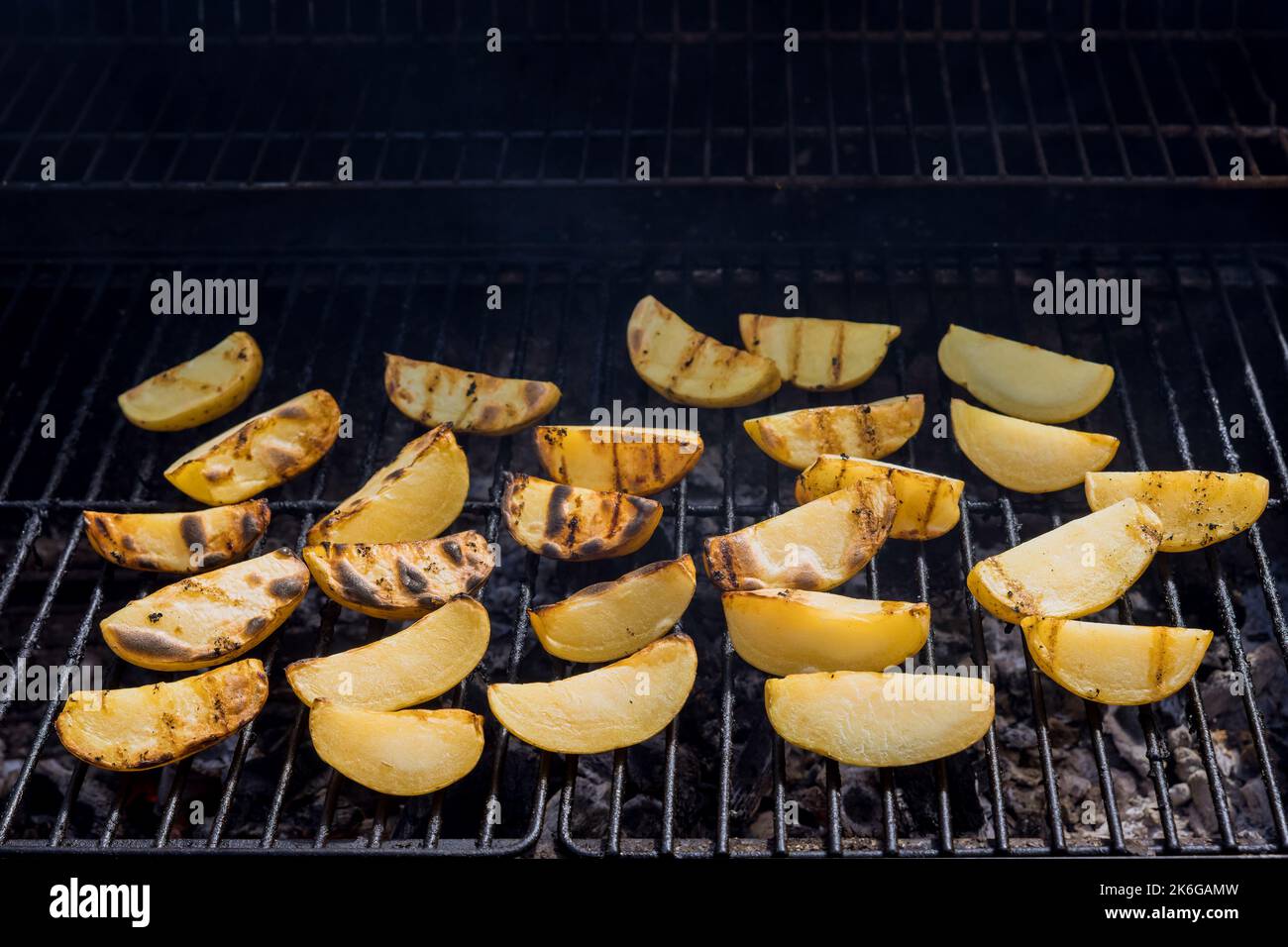 Roasted potatoes on BBQ grill using traditional cooking method Stock