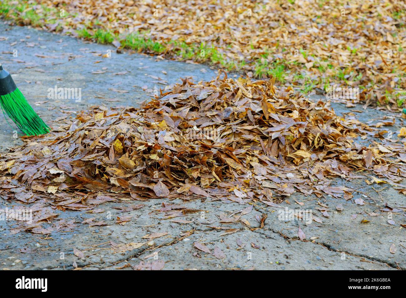In autumn, pile dried leaves that are piled up municipal workers clean on sidewalks Stock Photo