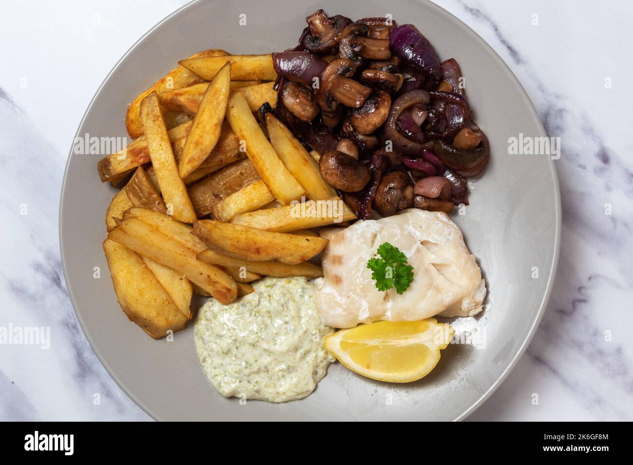 Baked cod loin, skin on chips, sauteed mushroom and red onion, tartare sauce, seen from above Stock Photo