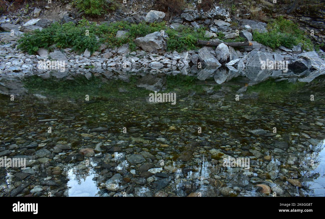 A scenic rocky coastline reflected in the river Stock Photo - Alamy