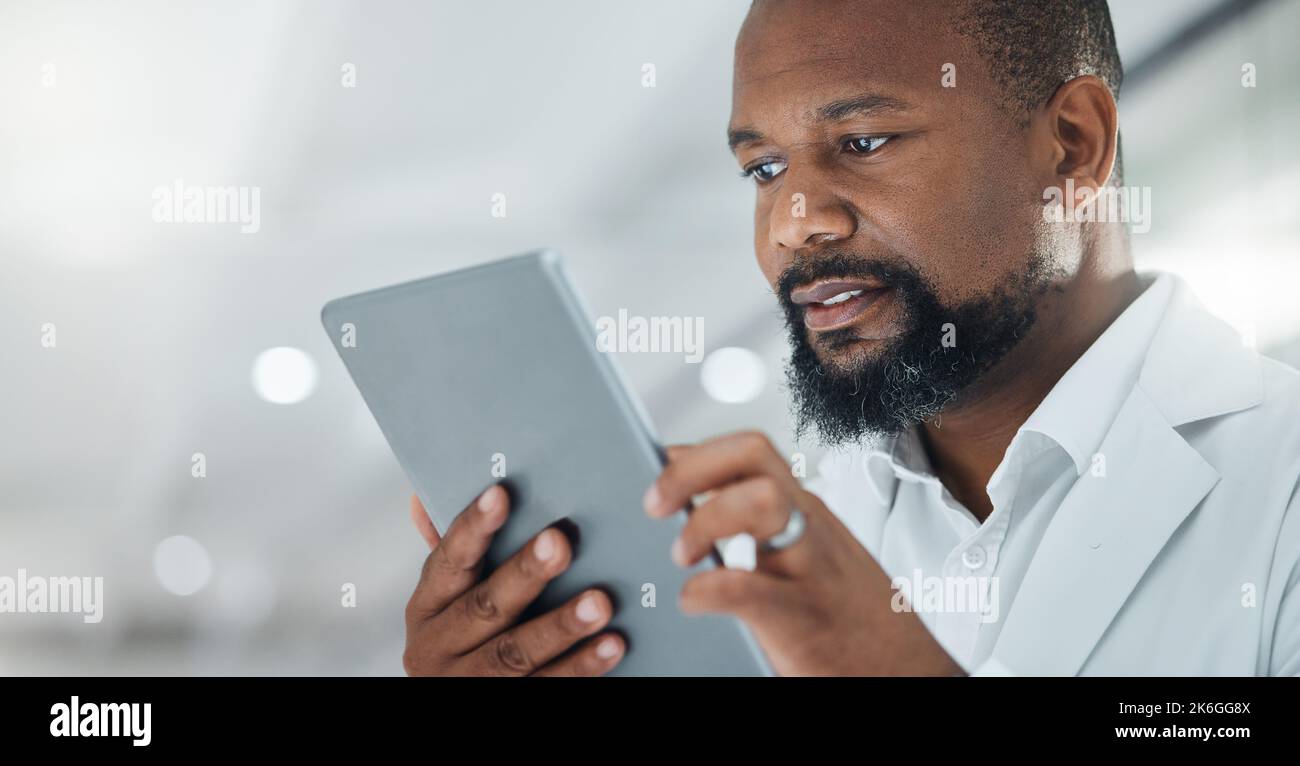 Science is all about extensive work. a male scientist using a digital tablet while working in a lab. Stock Photo