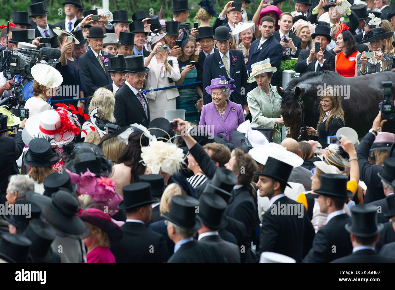 Ascot, Berkshire, UK. 20th June, 2013. Her Majesty the Queen and her daughter Princess Anne have a photo with the Queen's winning horse Estimate. This was an historic day as it was the first time a reigning monarch had won the Gold Cup. Estimate was ridden by jockey Ryan Moore. Queen Elizabeth II was due to the presentation for the Gold Cup but her son, the Duke of York did the presentation instead. Issue Date: 14th October 2022. Credit: Maureen McLean/Alamy Stock Photo