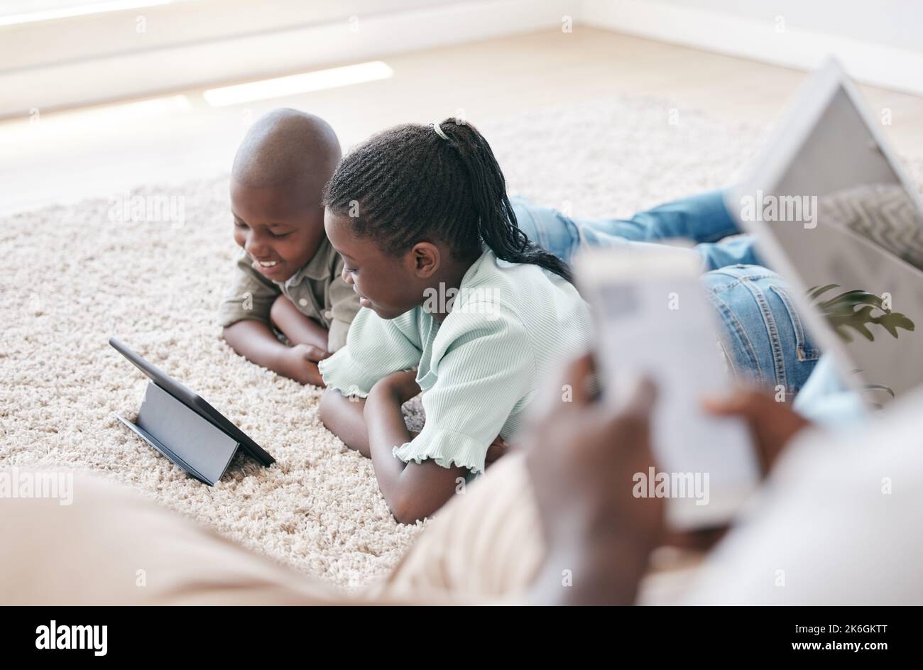 The memories we make with our family is everything. a brother and sister using a tablet at home. Stock Photo