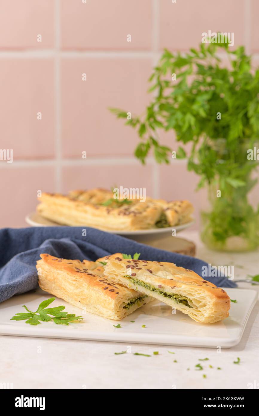 Spinach puff pastry with ricotta cheese and parsley leaves on white