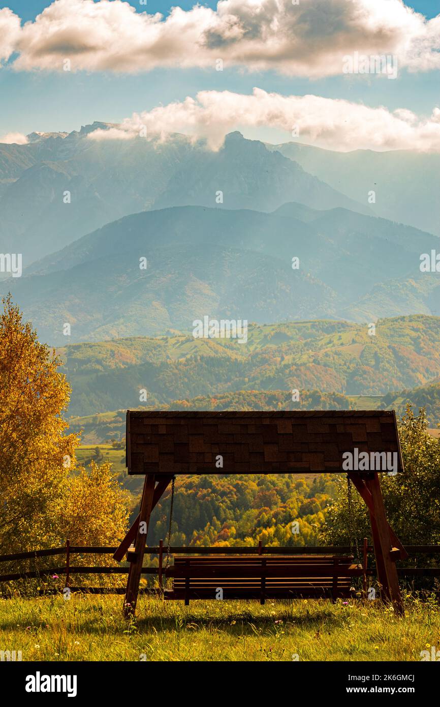 A swinging bench overlooking rolling hills and mountains bathed in god ...