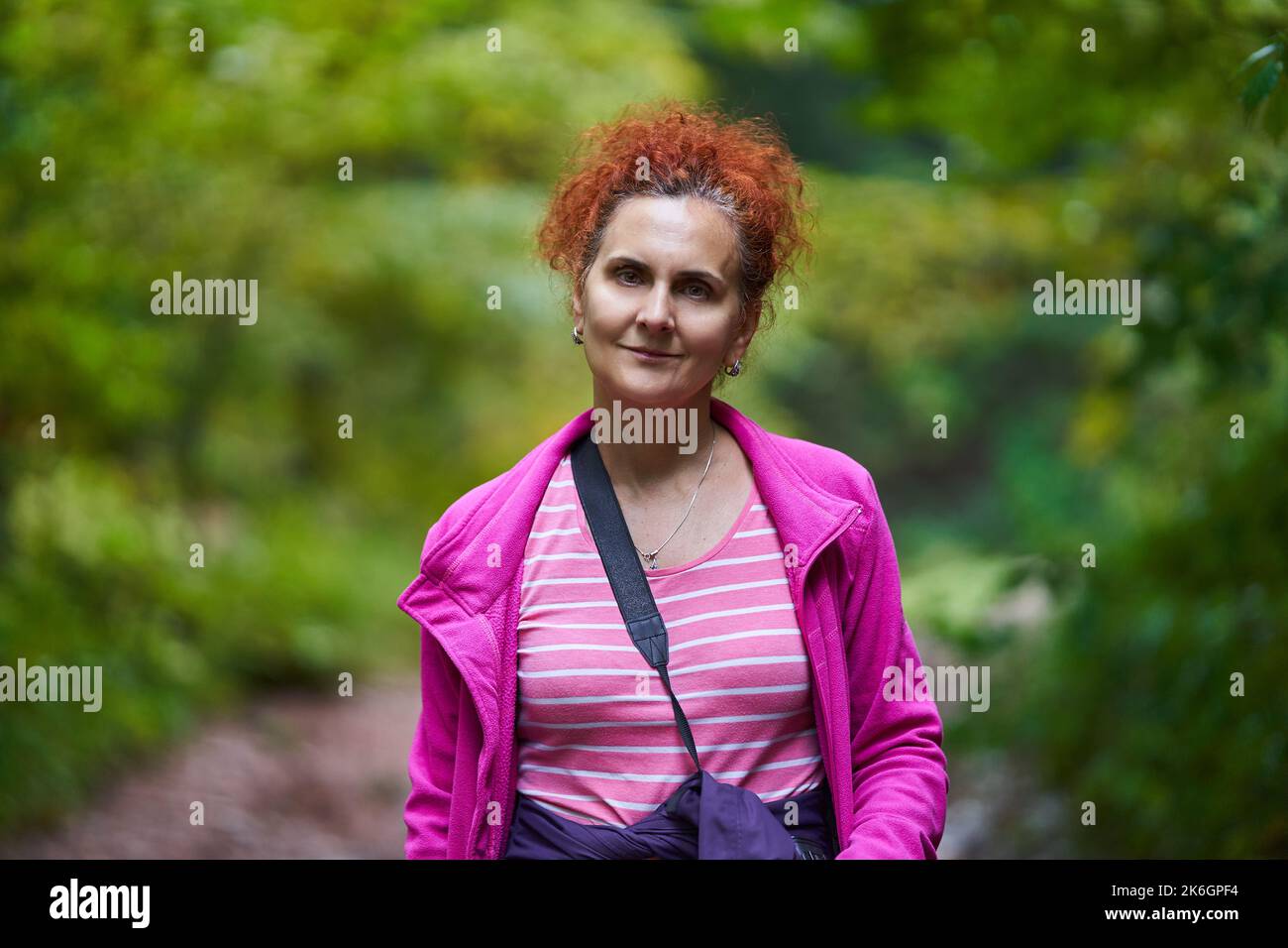Woman with curly hair, nature photographer, hiking in the mountain ...