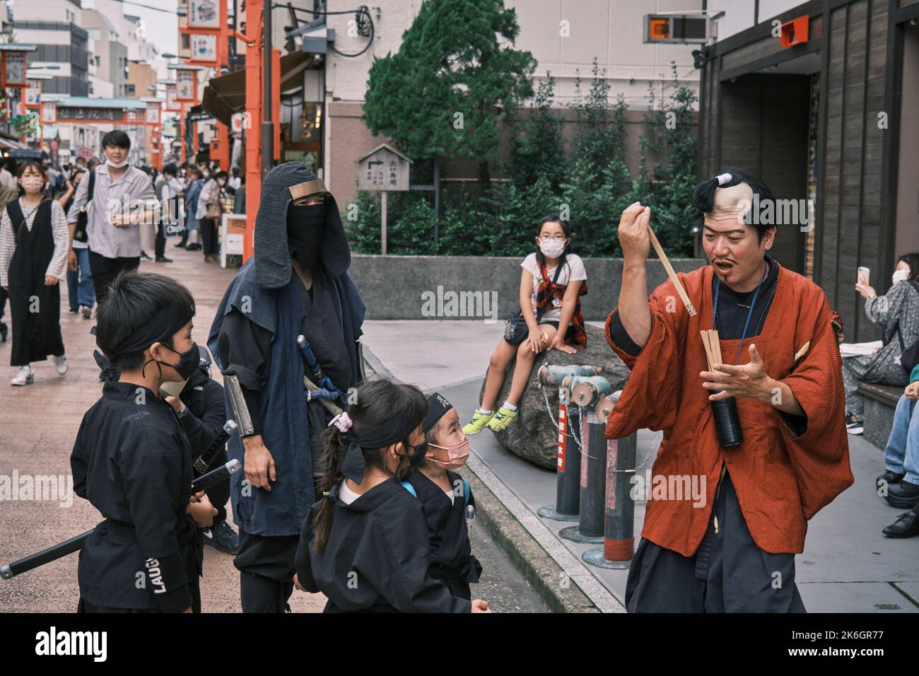 A Japanese traditional comedy actor dressing in Edo style with kids acting Ninja on street near the Asakusa area Stock Photo
