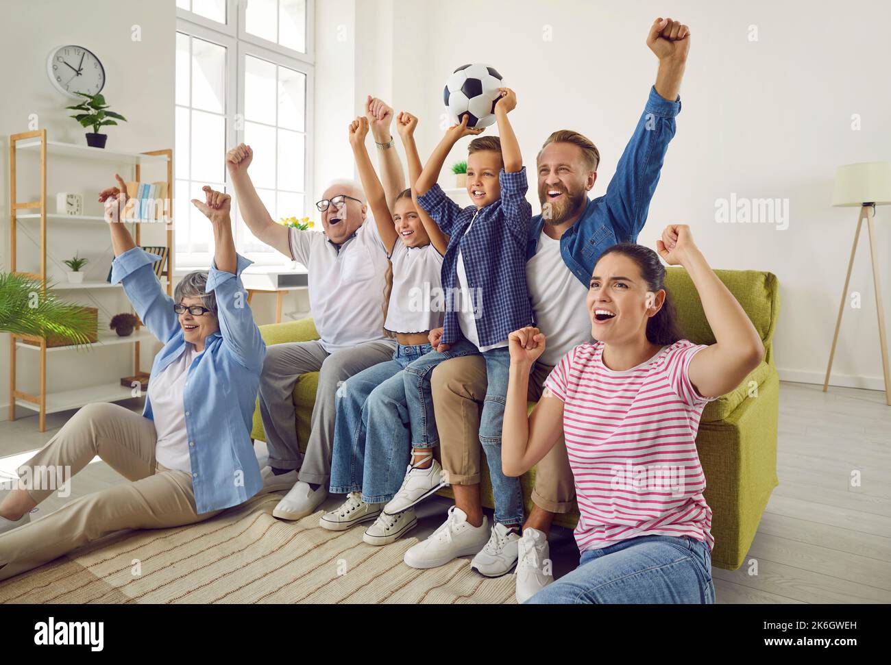 Super excited and happy big multi-generational family watching football match together. Stock Photo