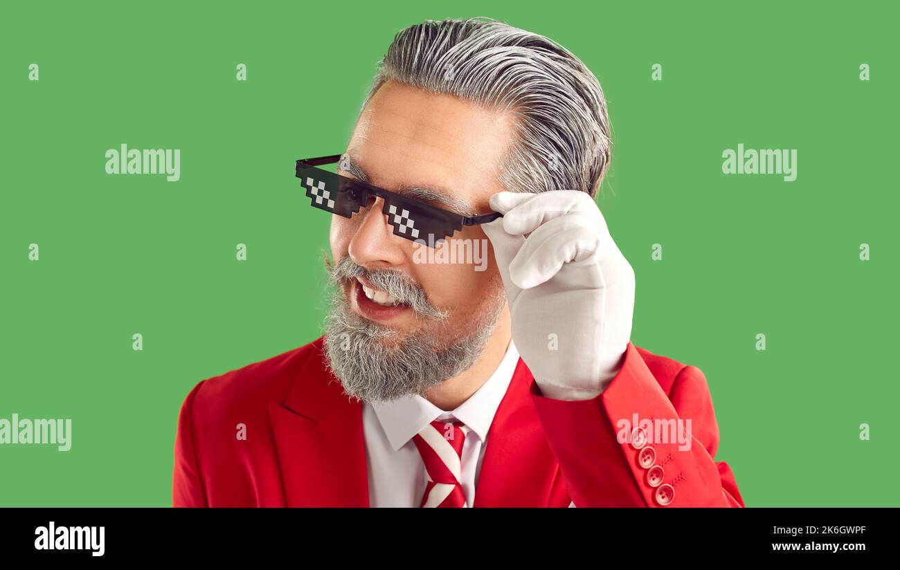 Portrait of adult bearded man in funny thug life spectacles and red Christmas suit Stock Photo