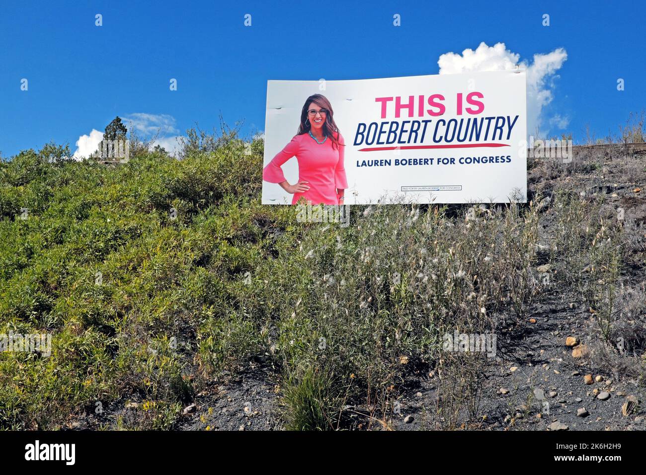 A political campaign billboard reading 'This is Boebert Country' referring to conservative politician Lauren Boebert sits on a hill in Pagosa Springs. Stock Photo