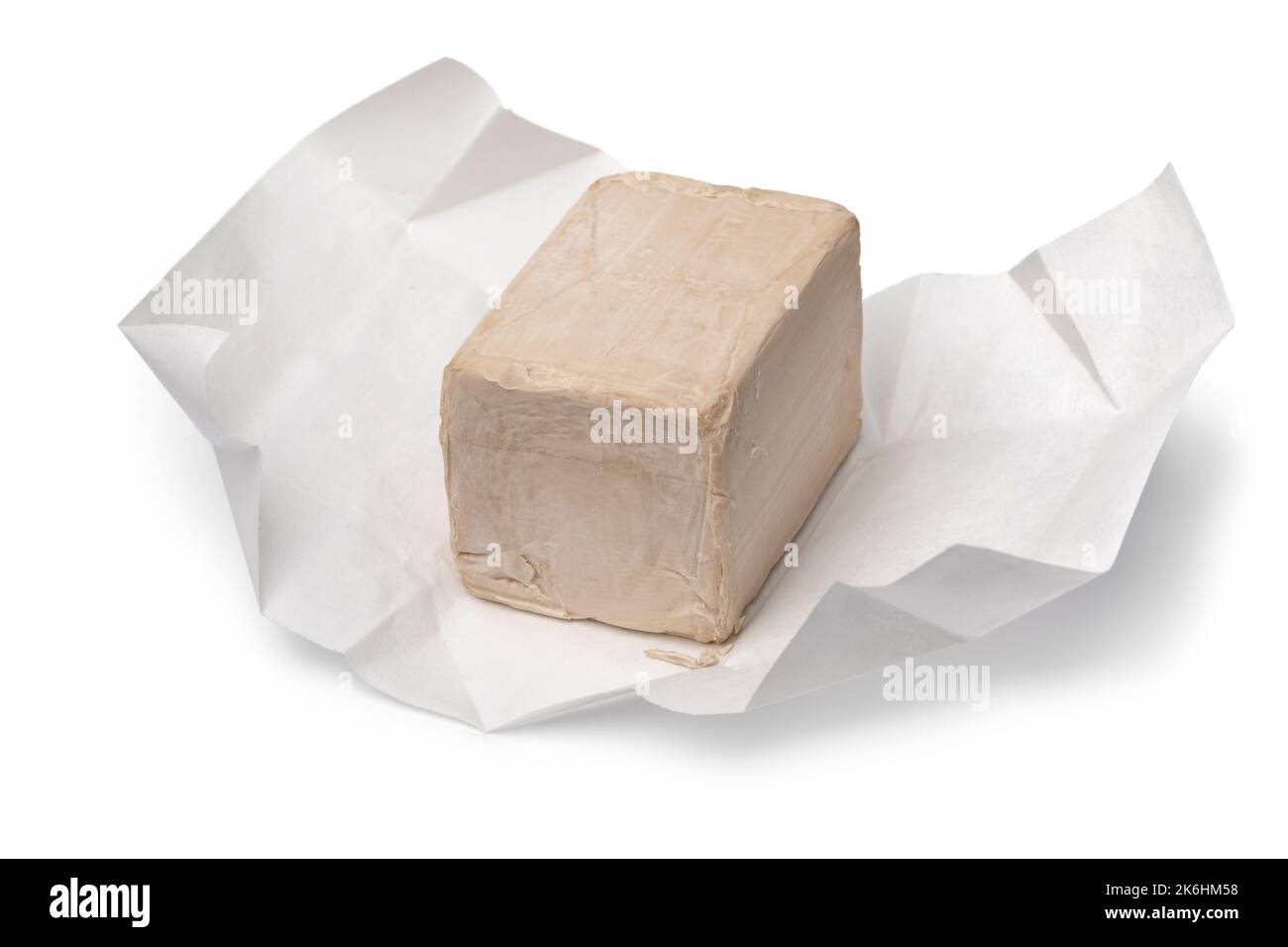 Single piece of fresh yeast on package paper isolated on white background close up Stock Photo