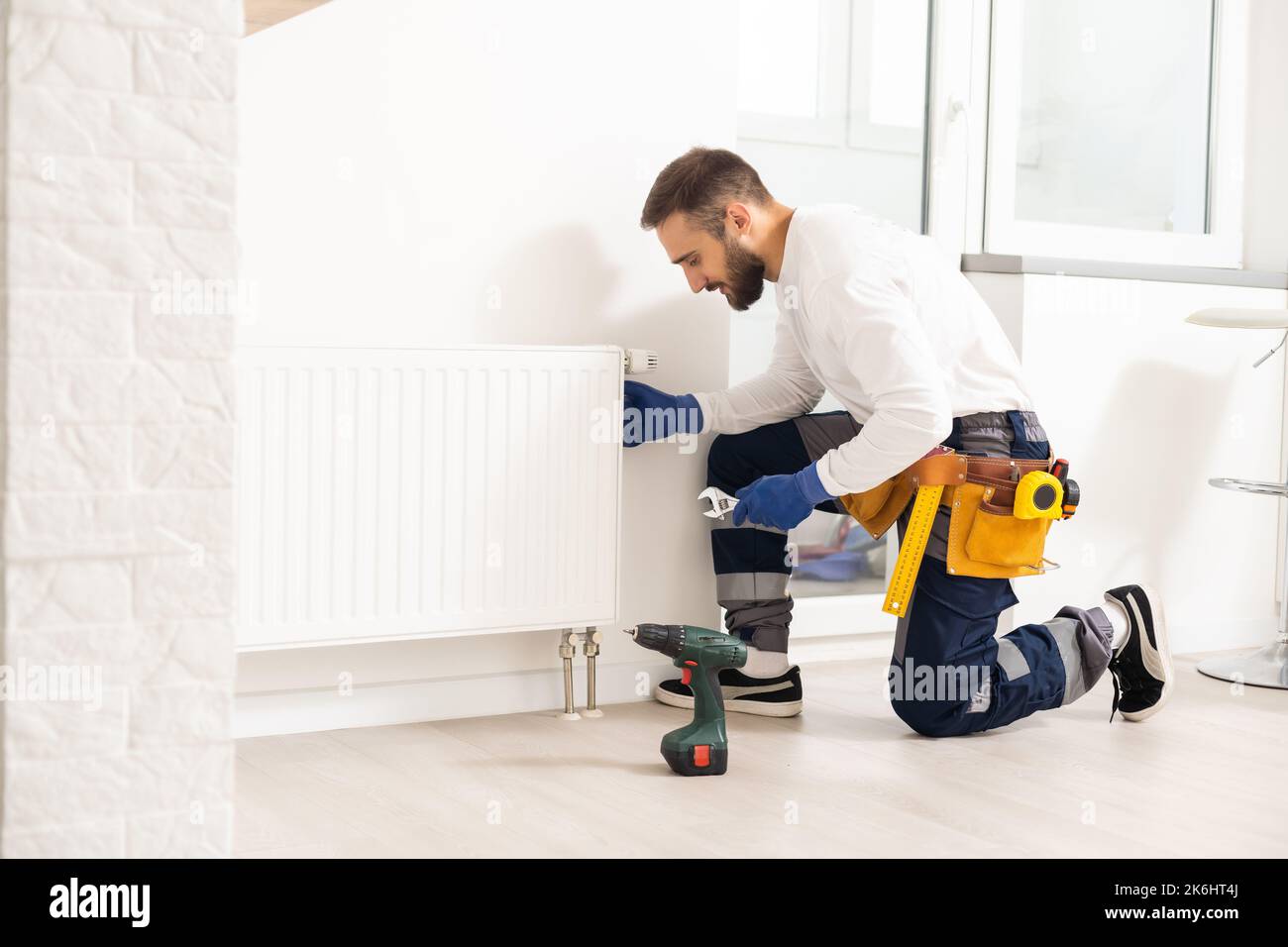 man repairing radiator with wrench. Removing air from the radiator ...