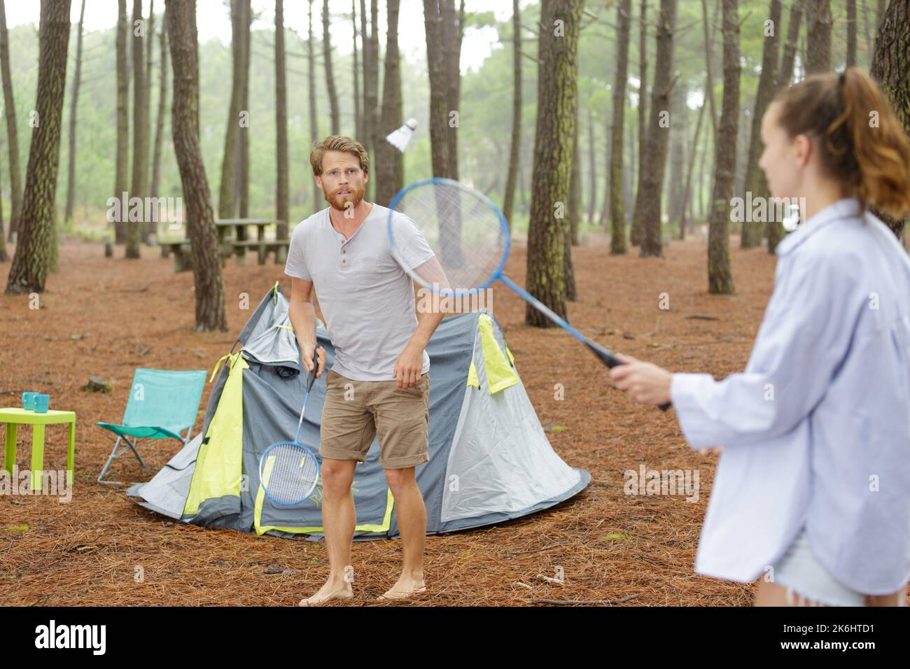 man reaching out hand to woman while playing badminton outdoors Stock ...