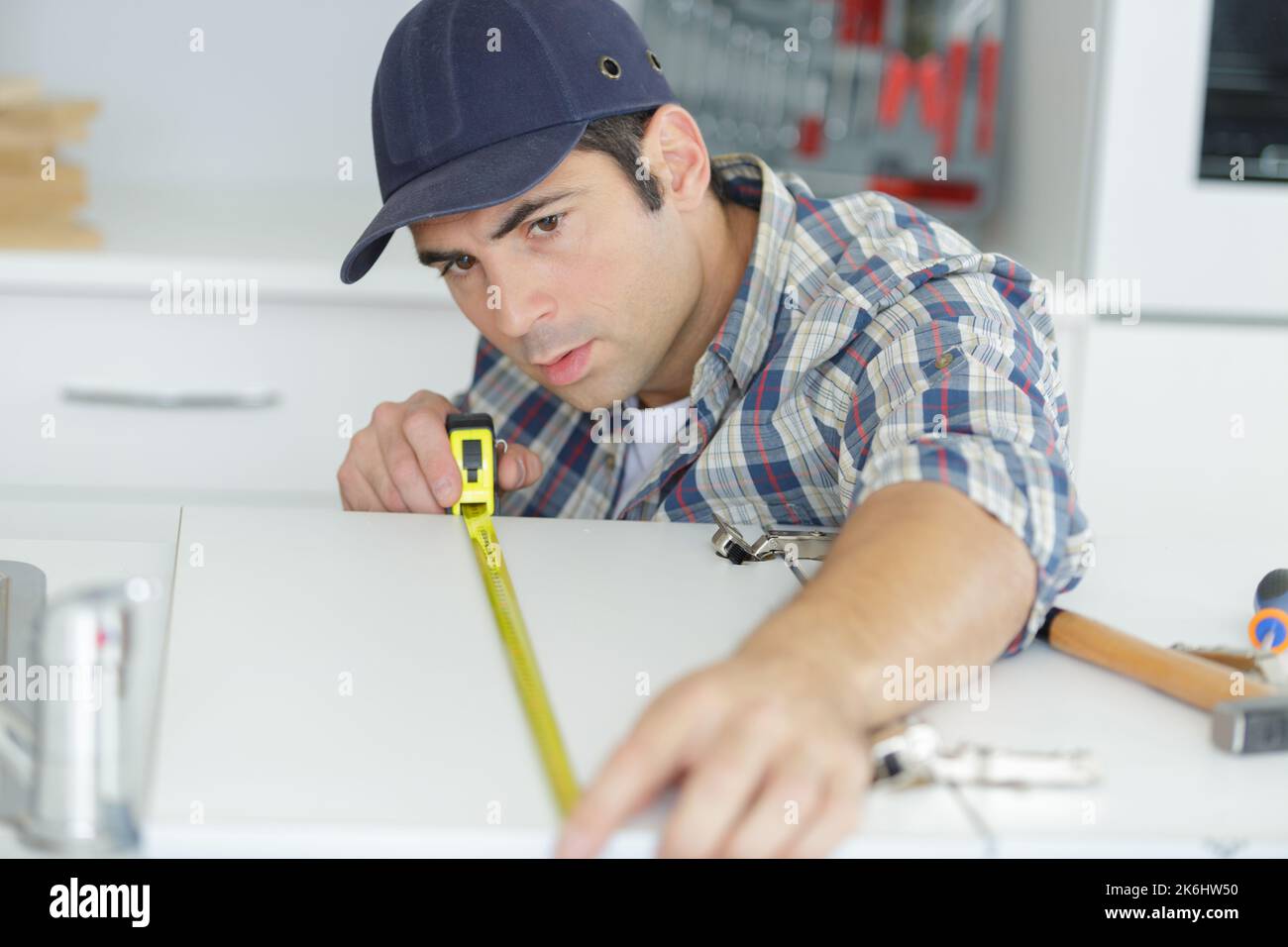man measuring worktop to fit new hob Stock Photo Alamy
