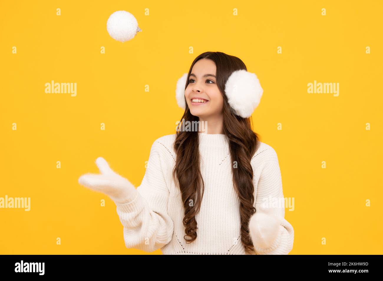 Merry christmas and happy New year. Kid in winter clothes. Teen girl with decorative snow ball. Stock Photo