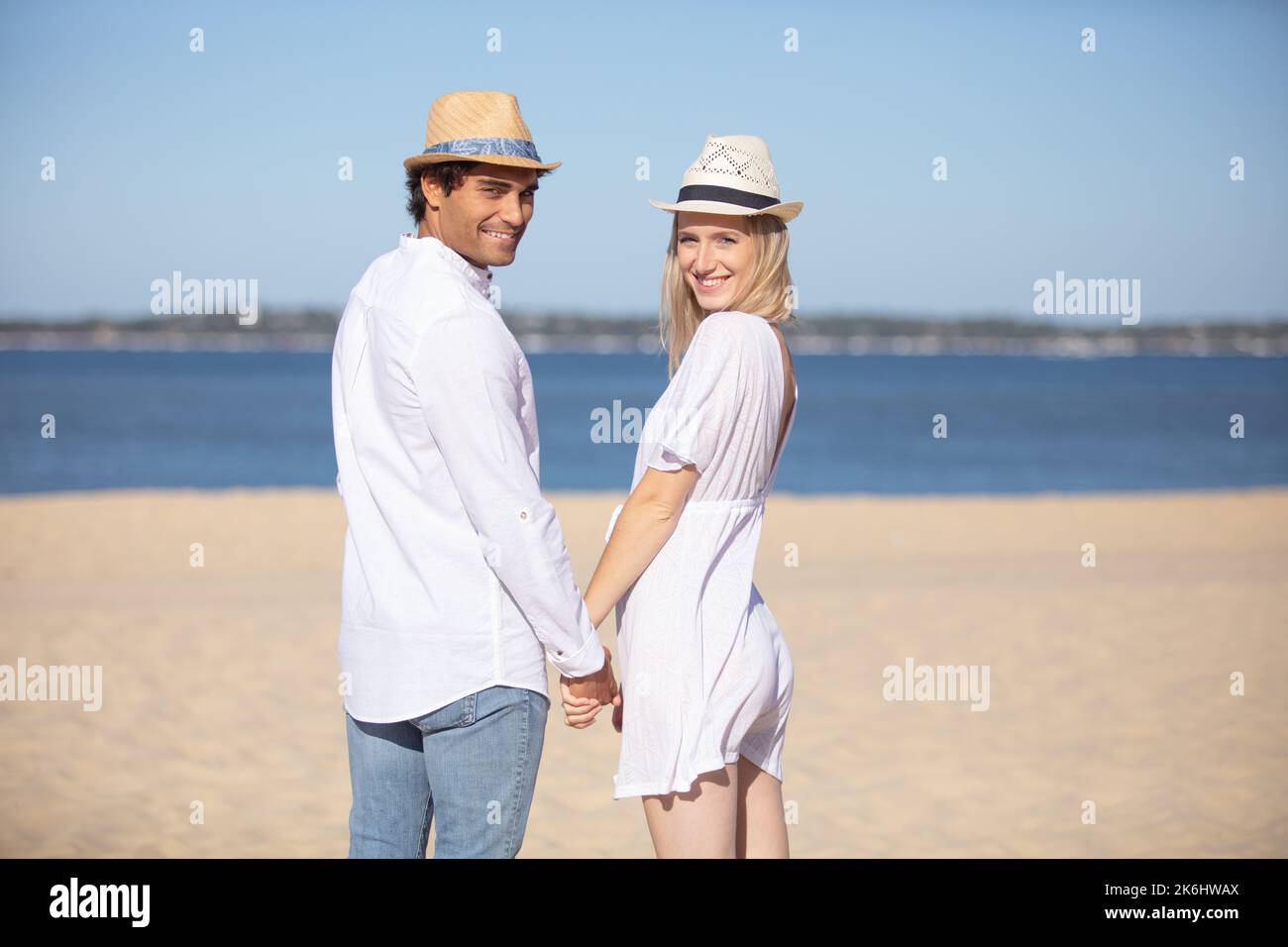 young couple holding hands on the beach Stock Photo