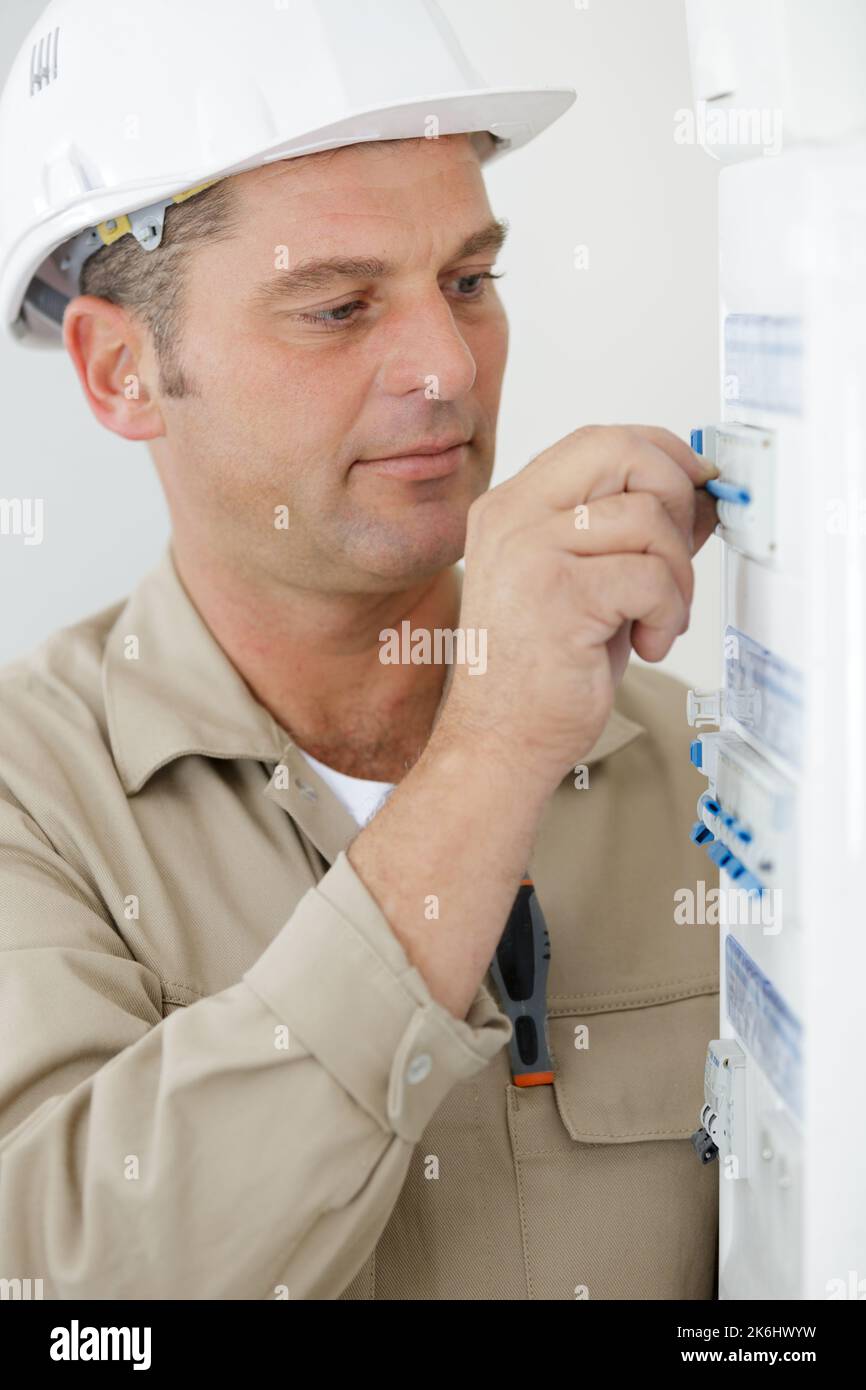 electrician resetting fuse in circuit breaker box Stock Photo Alamy