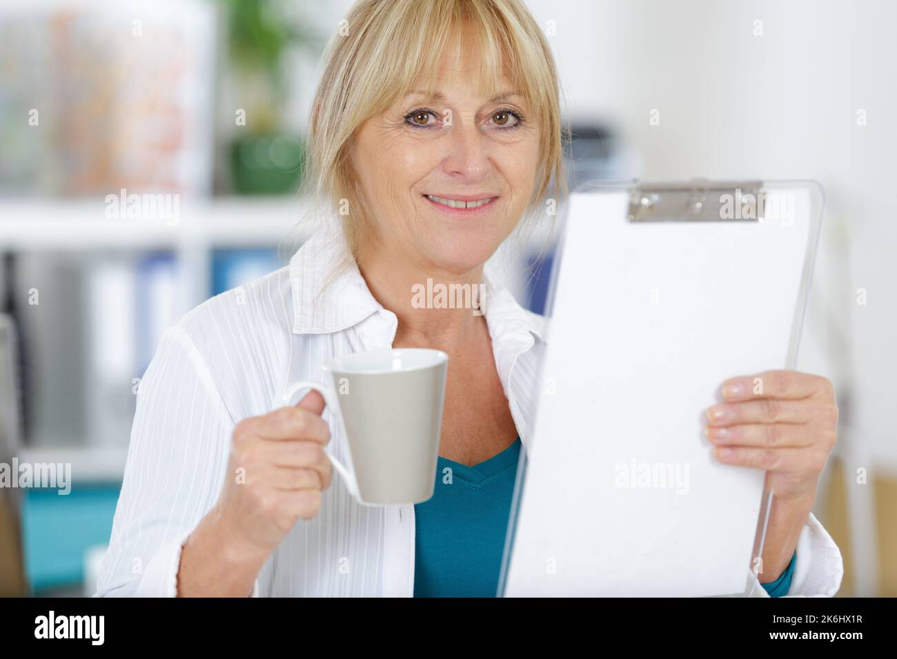 mature woman taking a coffee break in her office Stock Photo - Alamy