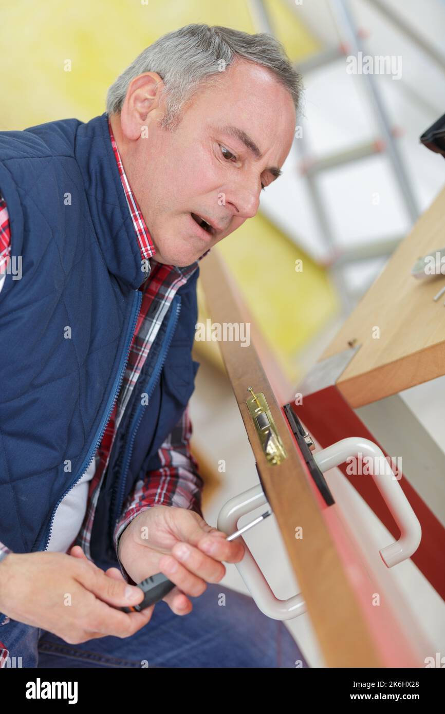 door installer adjusting the screws Stock Photo Alamy