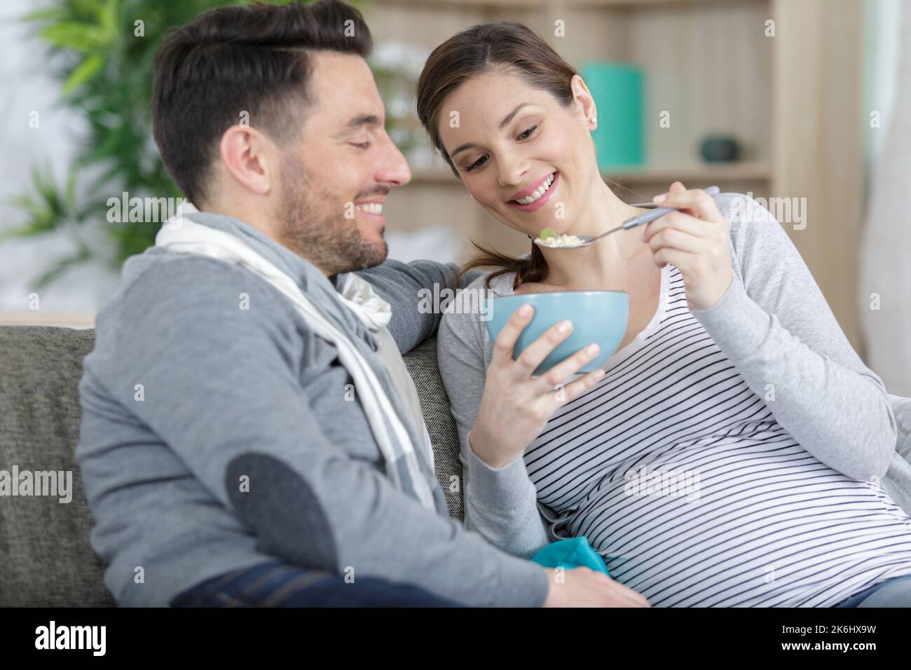 a couple is having breakfast on the sofa Stock Photo