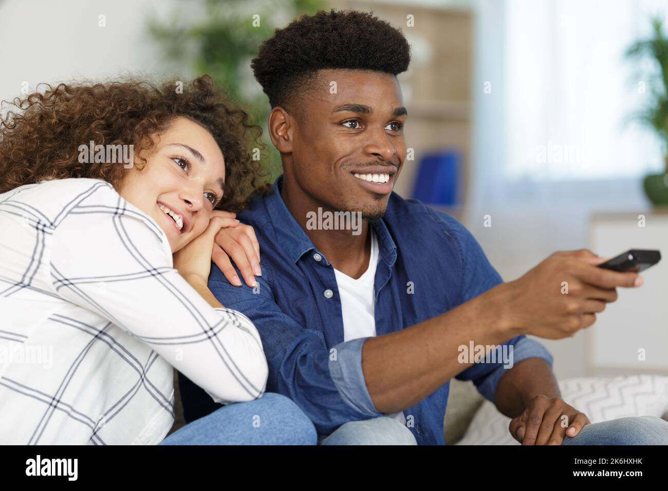 couple watching tv man using remote control Stock Photo - Alamy