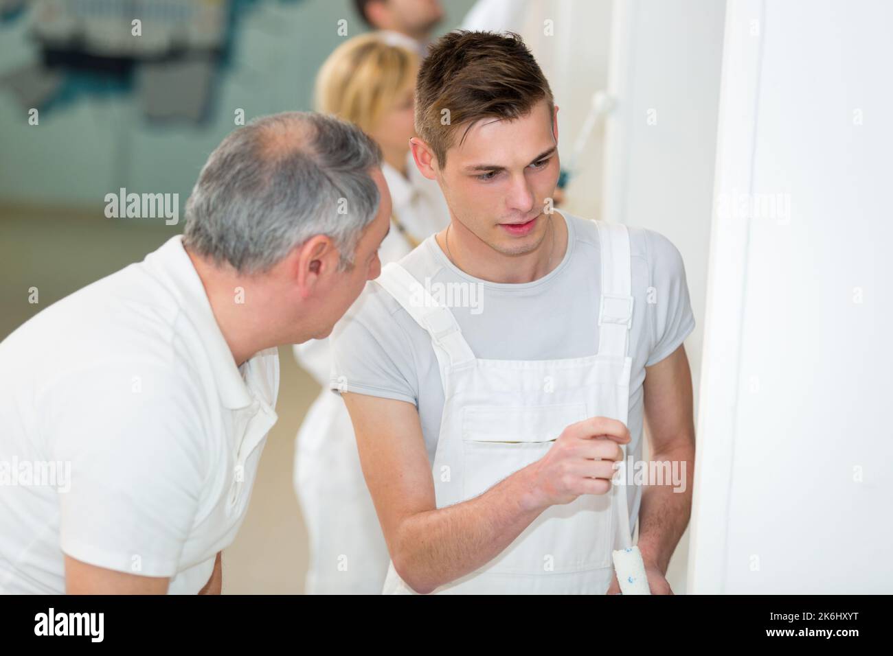 portrait of a painter watching apprentice working Stock Photo