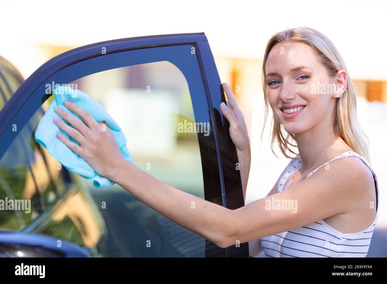 a woman cleaning a car window Stock Photo Alamy