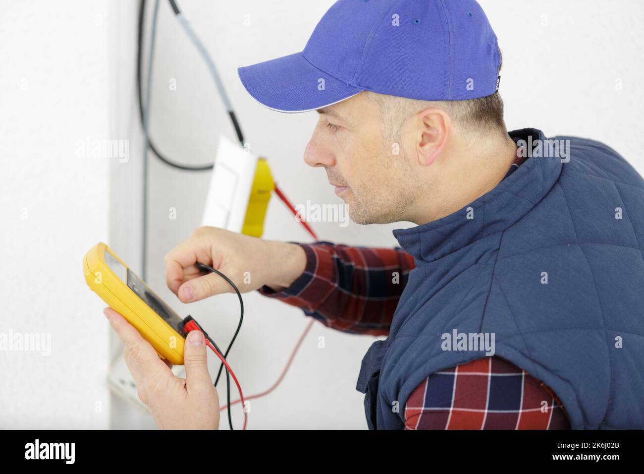 electrician reading the voltage of a socket Stock Photo - Alamy