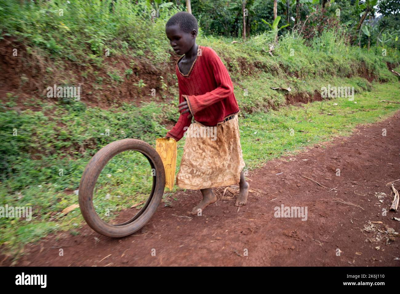 African child playing with an old tire on Mount Elgon in Uganda, East Africa. Stock Photo