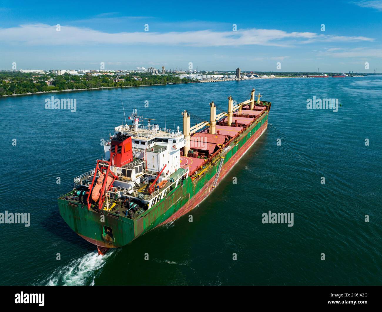 Aerial view of a fully loaded cargo ship leaving the Montreal Port and going downriver on the St.Lawrence River. Stock Photo